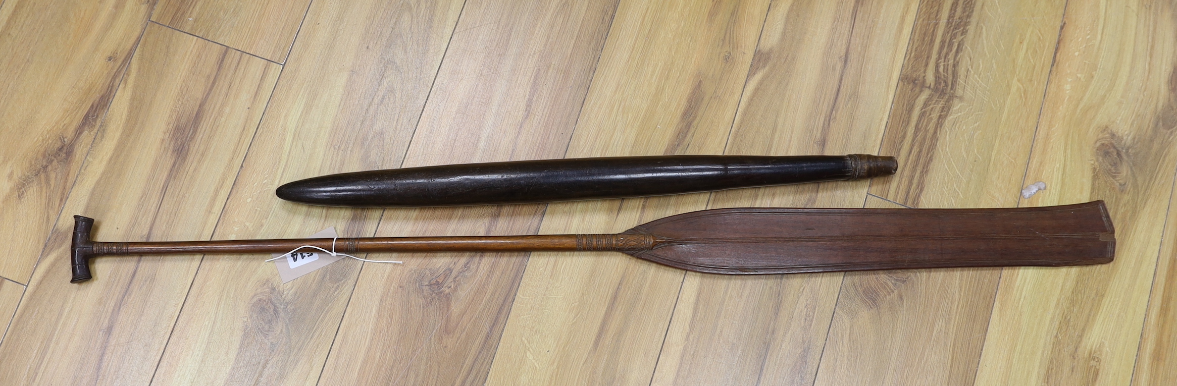 A 19th century Polynesian throwing club, possibly Fiji, and a 19th century ornamental Sri Lankan lady's paddle, 109cm long (2)